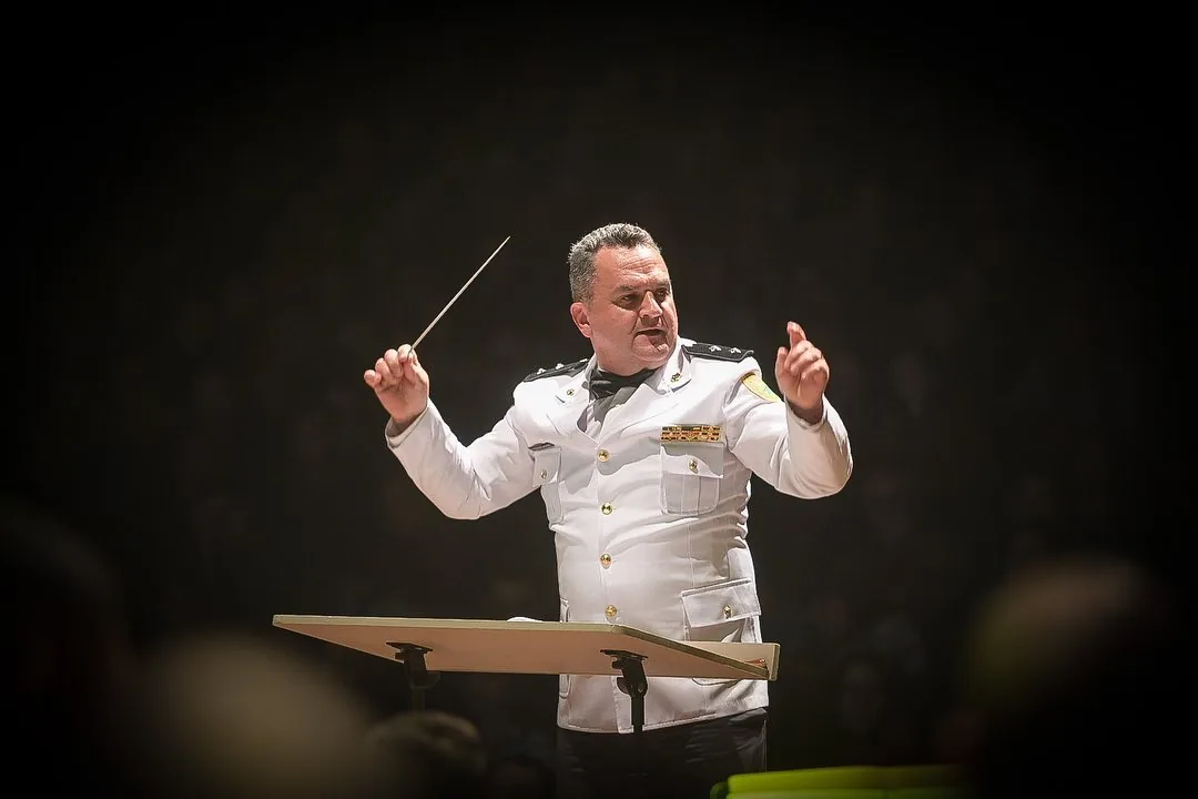 Maestro conduzindo uma apresentação musical.